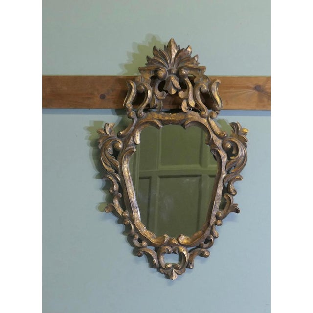 Attractive Baroque Style Small Gilt Wall Mirror The Mirror has an unusual shape, it has an elaborate wide carved gilt...