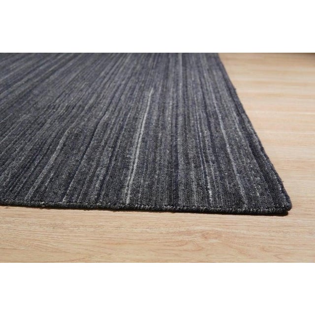 This hand knotted pile rug features a primary gray color and is crafted from high-quality wool material. Designed with a...