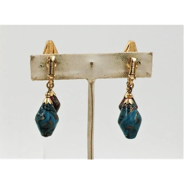 This is part of Chairish’s Costume Jewelry assortment. 1960s brushed goldtone turquoise with gold swirls art glass and red...