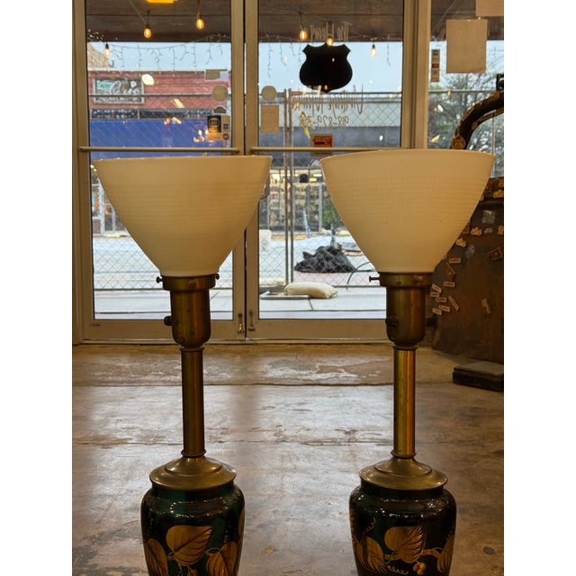 These lamps has brass fittings gilded porcelain, gilded handpainted leaves on green/teal glass insert and rises to a...