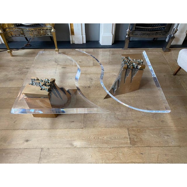 An unusual two-piece brass and acrylic coffee table, with moulded edge and curved shape with two organic cast brass...