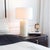 Natural bone is hand-inlaid onto the column base of the Trellis Table Lamp in a classic herringbone pattern. The varying...