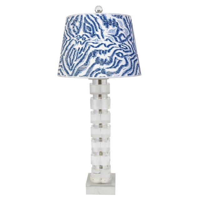 A vintage pair of lucite column lamps with a geometric stacked quatrefoil design on a square base. Each lamp takes two...