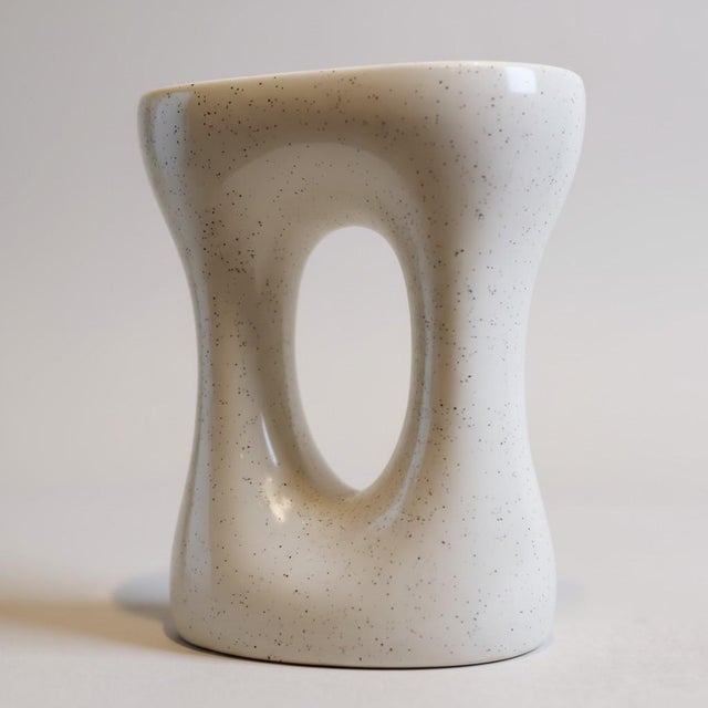 Truly timeless ceramic end table with a free form sculptural shape. Its freckled ivory paint and glossy finish leads this...