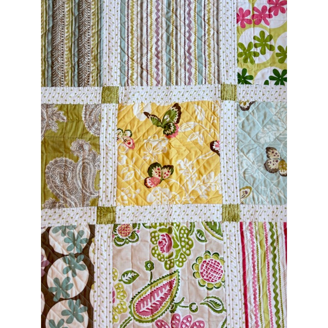 Bursting with cheerful garden-inspired color, this vintage handmade patchwork quilt celebrates the timeless charm of...