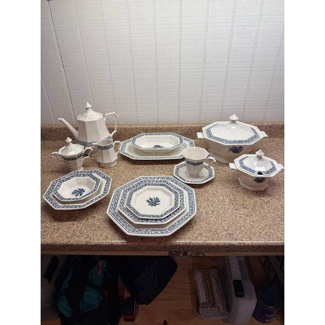 Vntage Independence Ironstone “Blue Tulip” octagonal dinnerware service, crafted in Japan. The set features a white...