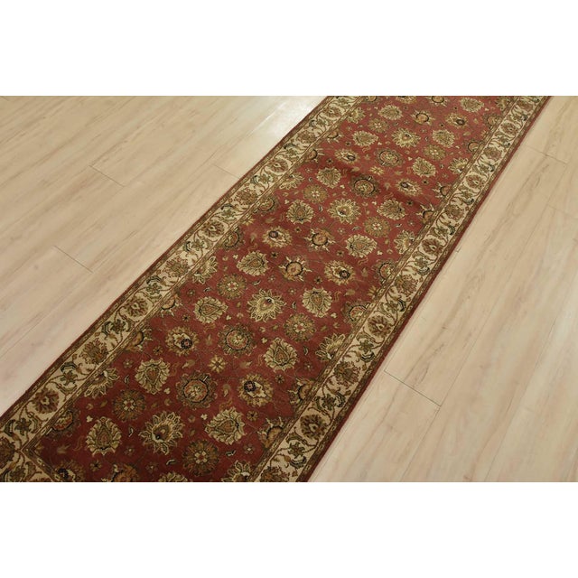 A traditional Agra runner hand-knotted with an all-wool pile on a cotton foundation. This finely woven oriental rug...