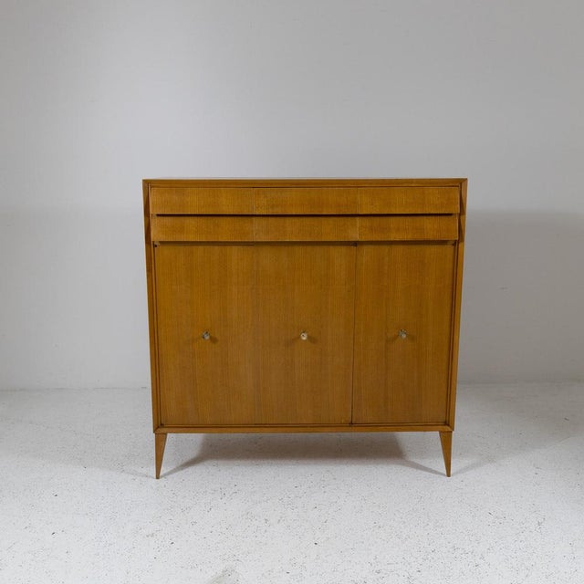 Ash wood highboard with turned brass handles, Italian production from the 1950s. It features three lower doors with shelf...