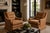 A pair of vintage club chairs upholstered in a brown, rust, and beige vertical striped fabric. The chairs feature tufted...