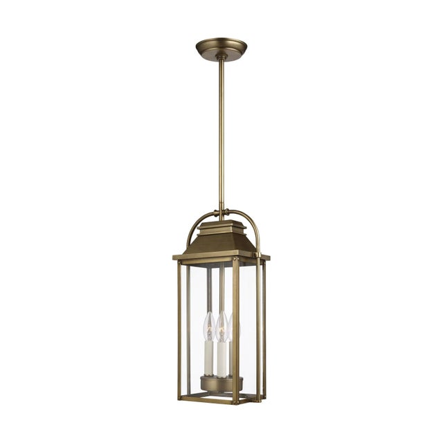 The Sean Lavin Wellsworth three light outdoor pendant fixture in painted distressed brass enhances the beauty of your...