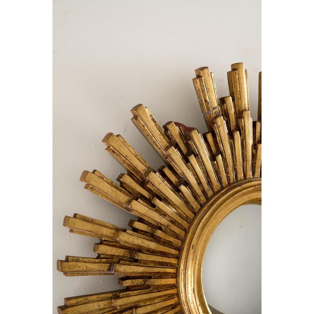 This vintage sunburst wall mirror embodies the glamour of Mid-Century Modern and Hollywood Regency design. Crafted in...