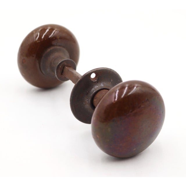 Antique dark brown ceramic passage door knobs paired with one cast iron rosette and keyhole. The original mounting screws...