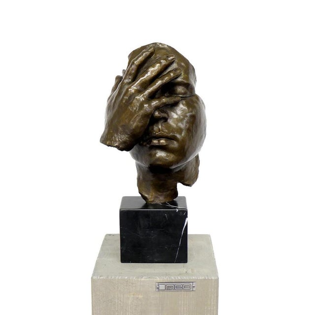 Bronze sculpture The Resignation inspired by Salvador Dalí, depicting a human head with a hand covering the face,...