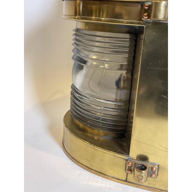 made by Perkins Marine Lamp Corporation of Brooklyn, New York. Fitted with a glass fresnel lens. Old lacquered finish....