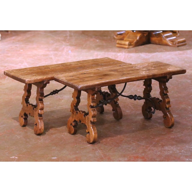This handsome pair of Spanish walnut trestle tables or benches was crafted in Spain circa 1950 and reflects a mid-century...