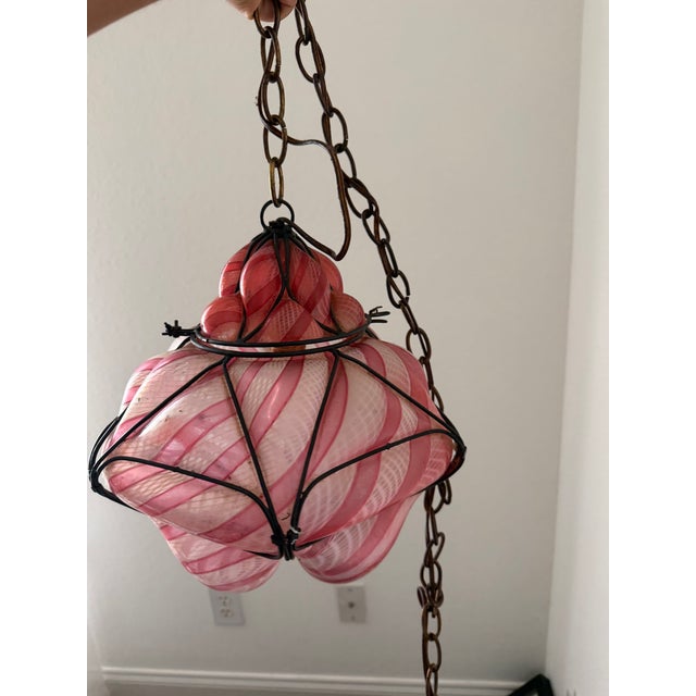 Vintage mid-20th-century Venetian Murano hand-blown caged glass pendant light featuring pink and white latticinio striped...