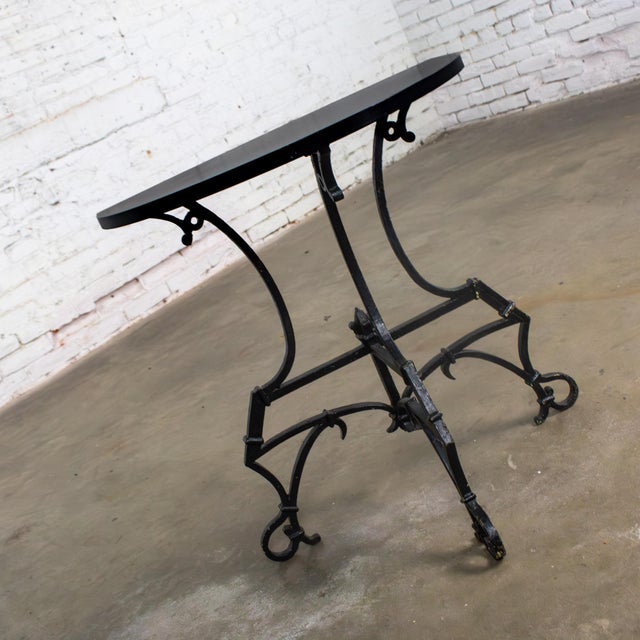 Handsome vintage Art Deco to Art Nouveau Italianate demilune table composed of a black painted hand wrought iron base with...