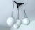 Vintage mid century pendant lamp featuring a cascade arrangement of four opaline globe glass shades with chrome caps and...