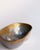 A cast metal empty-pocket by David Marshall, defined by a low, sculptural form and a clear horizontal division in...
