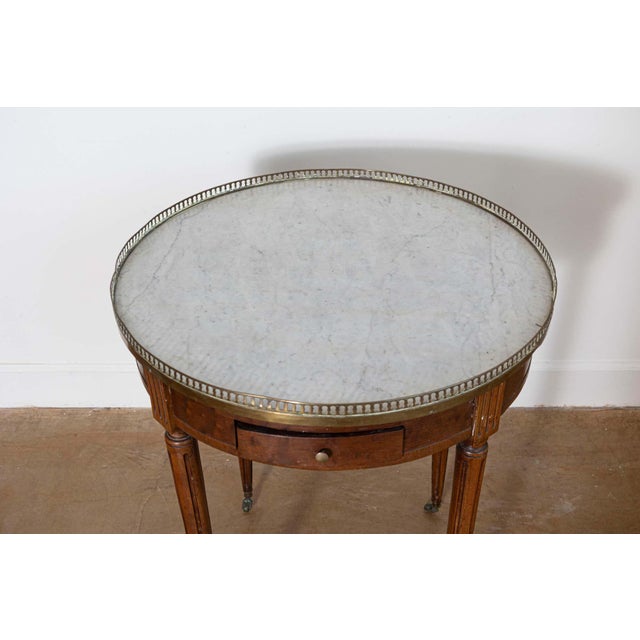 This 19th-century French Bouillotte table showcases the elegance and functionality characteristic of neoclassical design....