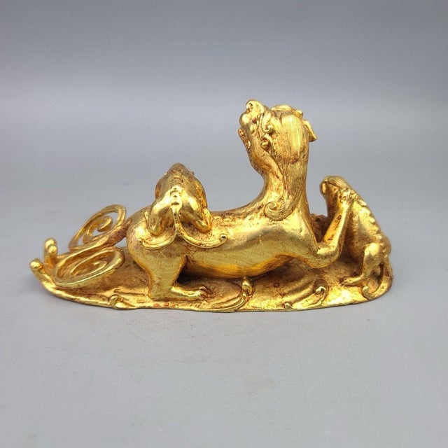 This charming gilt bronze sculpture depicts a family of guardian lions, or Foo Dogs, resting together on an integral base....