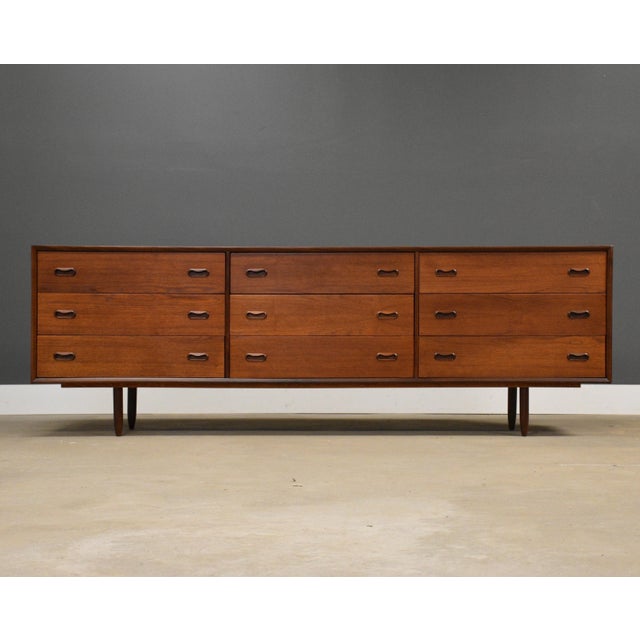 A mid century modern teak nine drawer long dresser with inset pulls and tapered legs. Made in Denmark. Circa 1960’s....