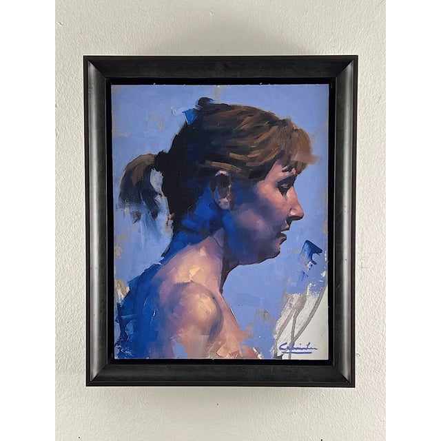 This artwork captures a serene profile of a woman against a soft blue background, emphasizing the subtle play of light and...