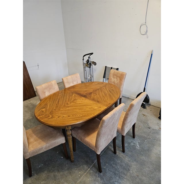 A charming vintage dining set featuring a solid oak oval extension table with a beautiful patterned top. The table rests...