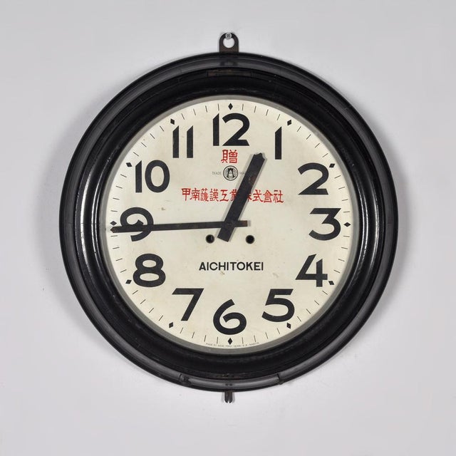 This wooden wall clock by Aichi was produced in Japan in the 1920s. with its round, black wooden frame and easy-to-read...