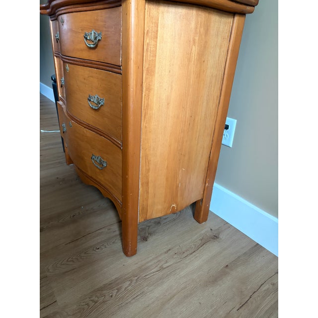 Charming vintage three-drawer bow-front dresser featuring a warm natural wood finish, gently curved drawer fronts and...