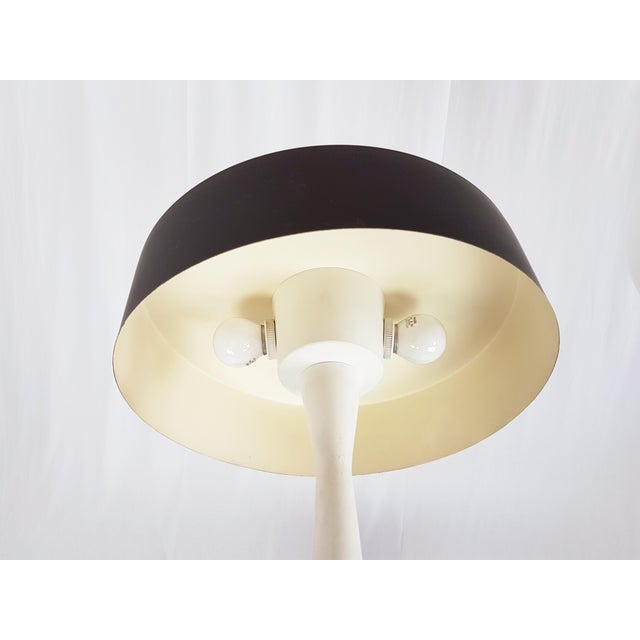 This Mid-Century table lamp was produced in Italy in the style of Stilnovo. It is made from laquered aluminum with brass...