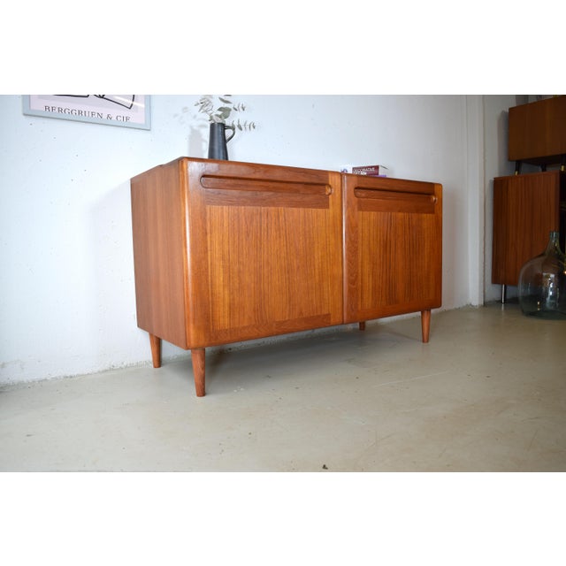 This is a Danish teak sideboard from Kollund Möbler. The sideboard embodies the design principles of Scandinavian...