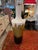 Tall vessel or urn handmade with plaster and other sculpting materials. The vessel is white with gold leaf, painted and...