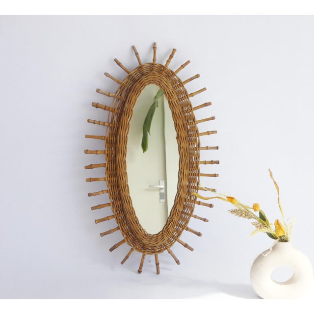 A vintage oval mirror made out of rattan and bamboo. The vintage French Riviera style mirror has a shape of a sun. Very...