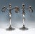 Two elegant, simple silver candle holders on a round stand, round foot grooved on the side, raised smooth shaft in the...