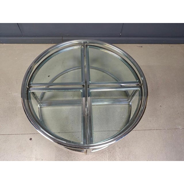 Chromed metal coffee table set with clear glasses. The set consists of 4 nesting tables underneath a round glass coffee...