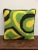 Wool and velvet pillow with colorful green, yellow and black embroidery.
