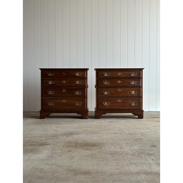 Pair of Georgian bachelor chests in a warm, even cherry tone. Each chest features four graduated drawers with original...