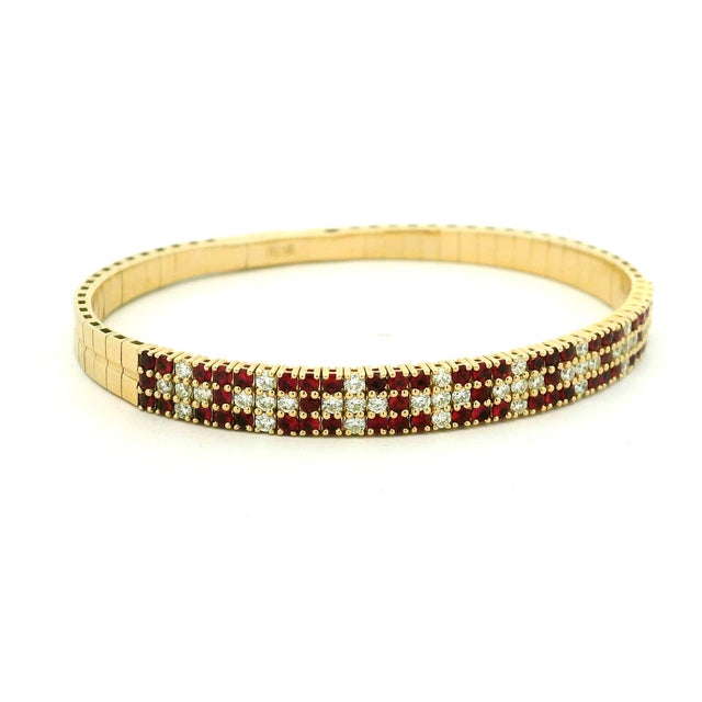 An elegant vintage ruby and diamond bracelet crafted in polished 14K yellow gold. Its fully articulated construction...