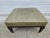 A classic 38-inch square footstool or ottoman with green upholstery and resting atop brass casters. This piece is in very...