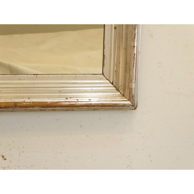 This bright lightly distressed silvereaf mirror has traces of old stenciling, is set up to hang vertically, though if you...