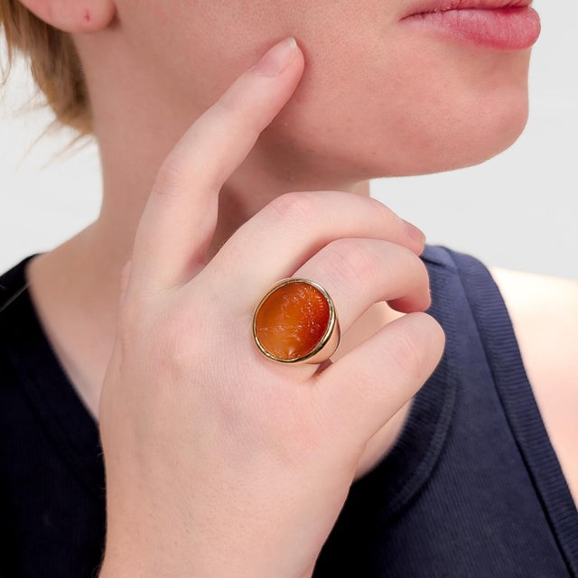 A fine antique gold and carnelian intaglio signet ring. In 14 karat yellow gold. With a bezel-set carnelian cabochon in a...