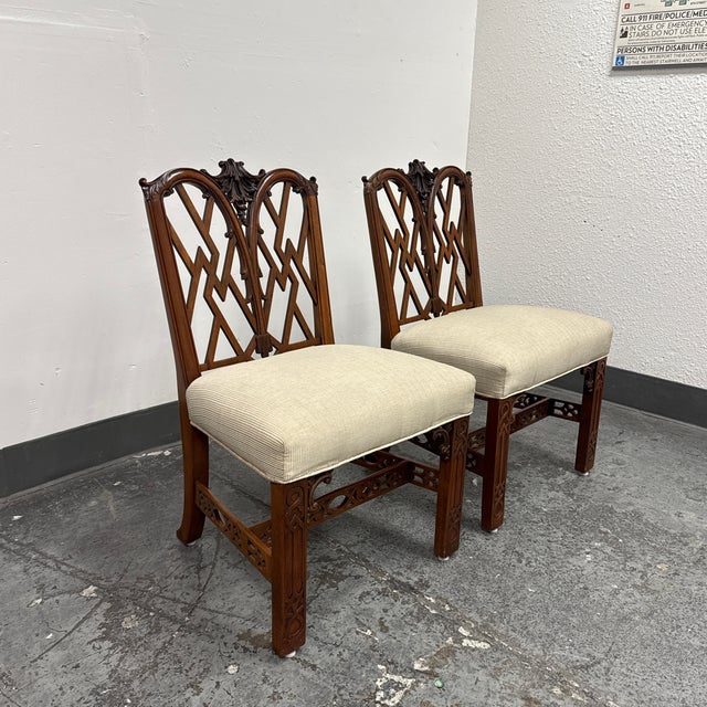 Design Plus Gallery presents a Pair of Vintage Chippendale Side Chairs. The pair showcases carved wood frames with arched...