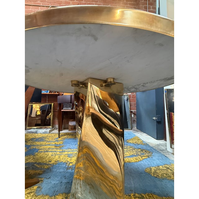 A striking contemporary dining table featuring a spectacular round top clad in genuine malachite, showcasing the stone's...
