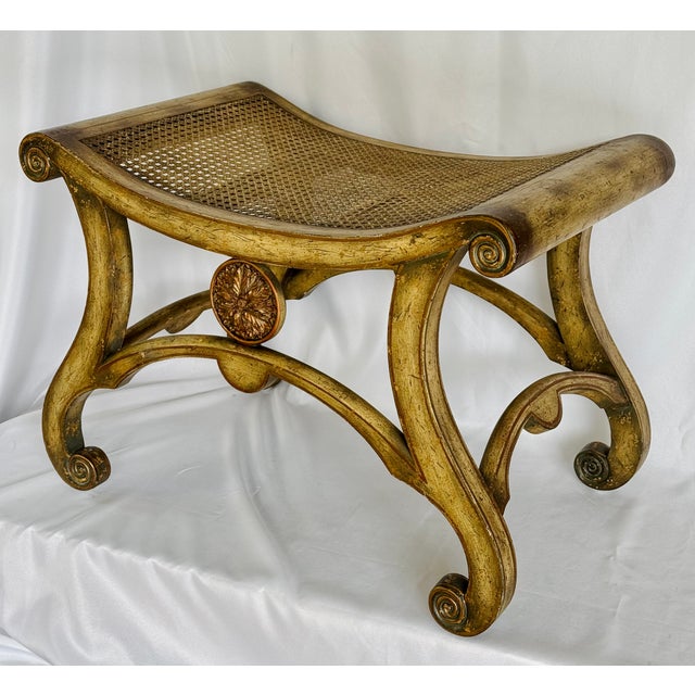 A wood and rattan painted bench. The finish with an applied antique patina and gilded highlights. Retains the original...