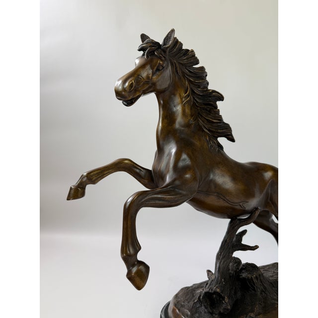 A dynamic bronze horse sculpture captured in a rearing, mid-motion pose, this piece emphasizes energy, balance, and...