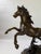 A dynamic bronze horse sculpture captured in a rearing, mid-motion pose, this piece emphasizes energy, balance, and...