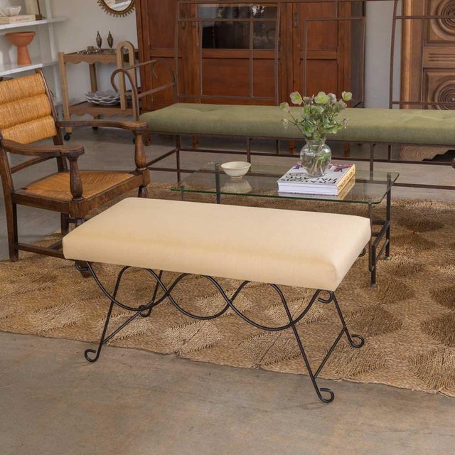Iron bench with beautiful curved and looped base with matte black painted finish. Rectangular cushioned seat upholstered...