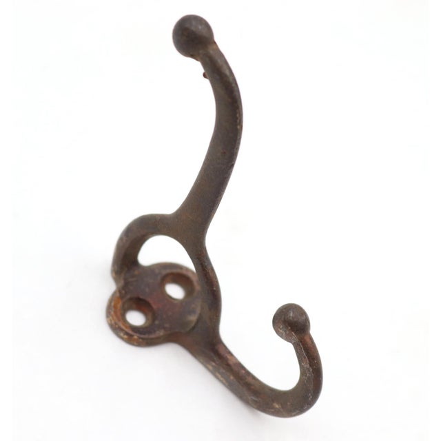 Antique cast iron wall hook with double arms with ball tips. Stamped C. The original mounting screws are not available....