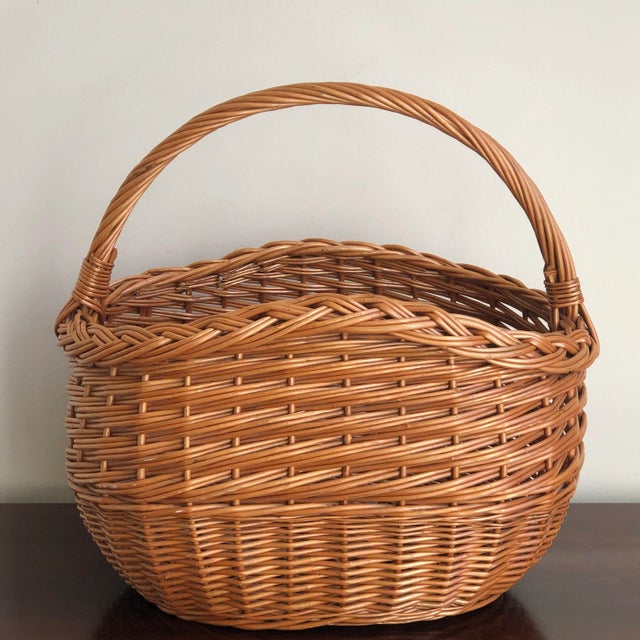 A real beauty, this rustic mid-20th century market basket features intricate handwoven designs, a braided rim, and French...